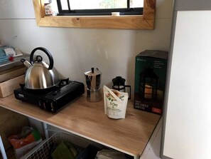 Une cuisine équipée d’une bouilloire, d’une machine à café et d’une boîte de bougies à LED.
