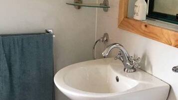 A bathroom with a white sink, a mirror, and a towel rack.
