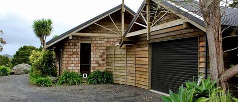 A single-story building with a brick facade, a garage door, and a gravel driveway.