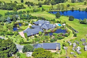A large estate with multiple buildings, a lake, and surrounding greenery.