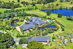 A large estate with multiple buildings, a lake, and surrounding greenery.