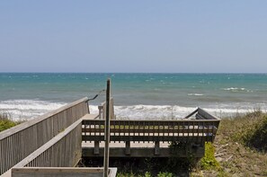 A wooden boardwalk leading to a beach with waves crashing onto the shore. - Sea Crest Oceanfront 6 bedroom, 5 bath wonderfully decorated & spacious home (Surf City)