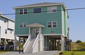 A two-story building with a porch and a staircase leading to the entrance. - Sea Crest Oceanfront 6 bedroom, 5 bath wonderfully decorated & spacious home (Surf City)