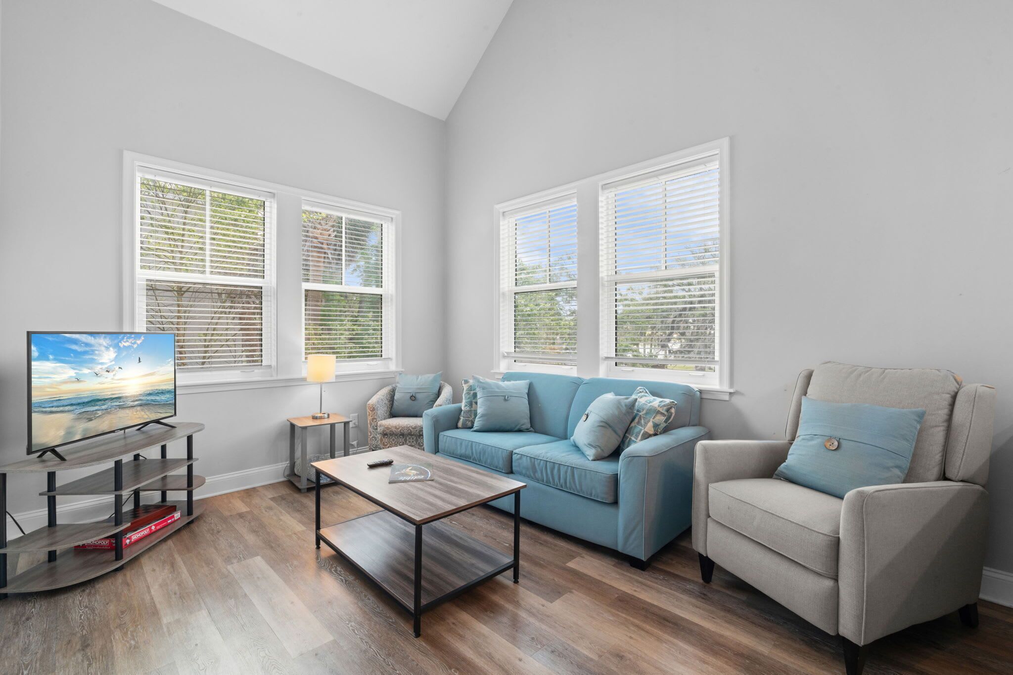 A living room with a TV, a sofa, a coffee table, and a chair.