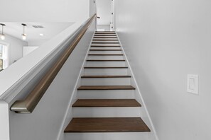 A staircase with wooden steps and white walls. - Villa Mojito Apartment A in Historic Downtown (St. Augustine)