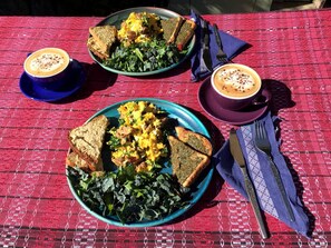 A table with two plates of food and two cups of coffee.