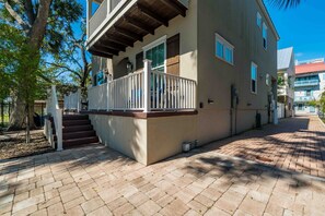 A two-story building with a balcony, a staircase, and a brick pathway. - Villa Mojito Unit B in Historic Downtown (St. Augustine)