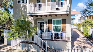 A two-story building with a balcony, a front door, and a small porch area with a bench. - Villa Mojito Unit B in Historic Downtown (St. Augustine)