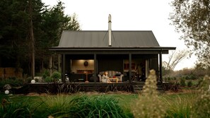Una casa moderna con un porche cubierto, chimenea y jardín.