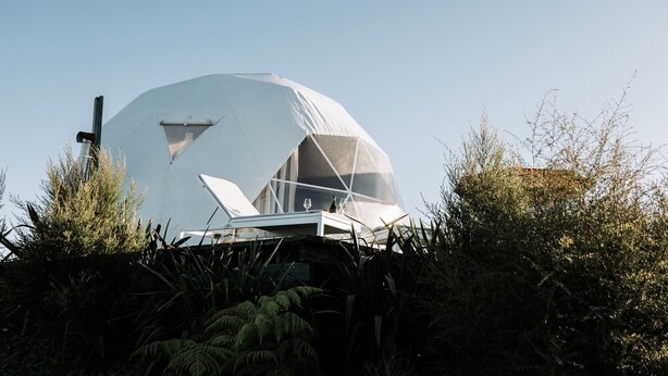 A geodesic dome structure with a table and chairs in front, surrounded by vegetation. - Isolated Dome Ideal for a Romantic Getaway in Rangiriri, New Zealand (Rangiriri)