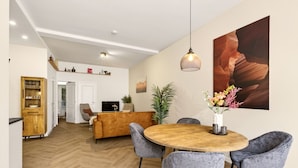 A modern living room with a sofa, dining table, chairs, and a TV. - Amstel l Family friendly l Fully equipped l Unit L (Amsterdam)