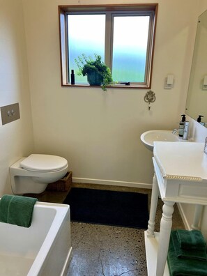 A bathroom with a toilet, sink, and bathtub. - Deluxe Cabin Rental in Stunning Setting near Tasman, South Island (Mahana)