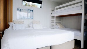 Ein Schlafzimmer mit einem großen Bett, einem Etagenbett und einem Fenster mit Blick.