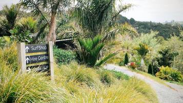 A signpost with directions to a surf shop, hire center, and a lookout point.