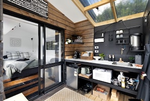 A compact kitchen with a built-in stove, a sink, and a window above the counter.