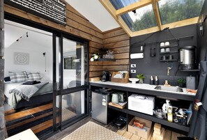 A compact kitchen with a built-in stove, a sink, and a window above the counter.