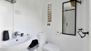 A bathroom with a white sink, toilet, and mirror.