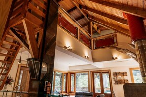 A spacious interior with a high ceiling, wooden beams, and large windows.