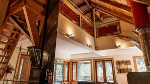 A spacious interior with a high ceiling, wooden beams, and large windows.