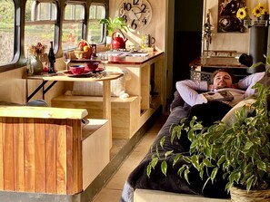Ein gemütliches Interieur mit einem Holztisch, einer Couch und einer Person, die darauf liegt.