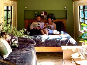 Ein Zimmer mit einem Bett, einem kleinen Tisch und einem Fenster.