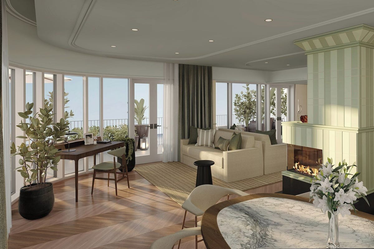 A spacious living area with a fireplace, large windows, and a dining area with a round table.