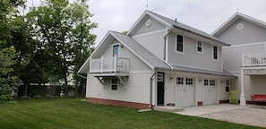 A two-story house with a front porch, a garage, and a fenced backyard.