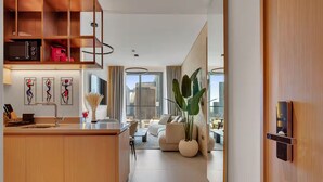 A modern kitchen with a built-in microwave, a sink, and a dining area with a white table and chairs.