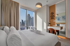 A hotel room with a large bed, a desk, a chair, and a view of the city skyline. - Khalifa View 5 Star Direct Dubai Mall (Dubai)