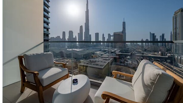 A balcony with a city view, including a prominent skyscraper.
