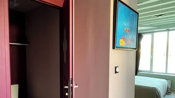 Une chambre avec un lit, un tableau et une salle de bain équipée de toilettes et d’une douche.