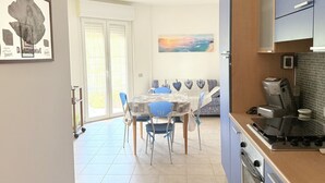 A dining area with a table, chairs, and a coffee machine. - SE182 - Senigallia, three-room apartment facing the sea with balcony and parking space (Senigallia)