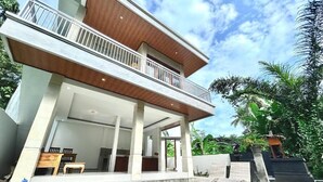 A two-story house with a swimming pool, outdoor furniture, and a balcony. - Widhiana Villa Ubud (Ubud)