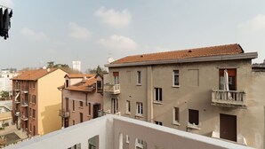 Ein Wohngebäude mit Balkonen, einer Satellitenschüssel und blauem Himmel.