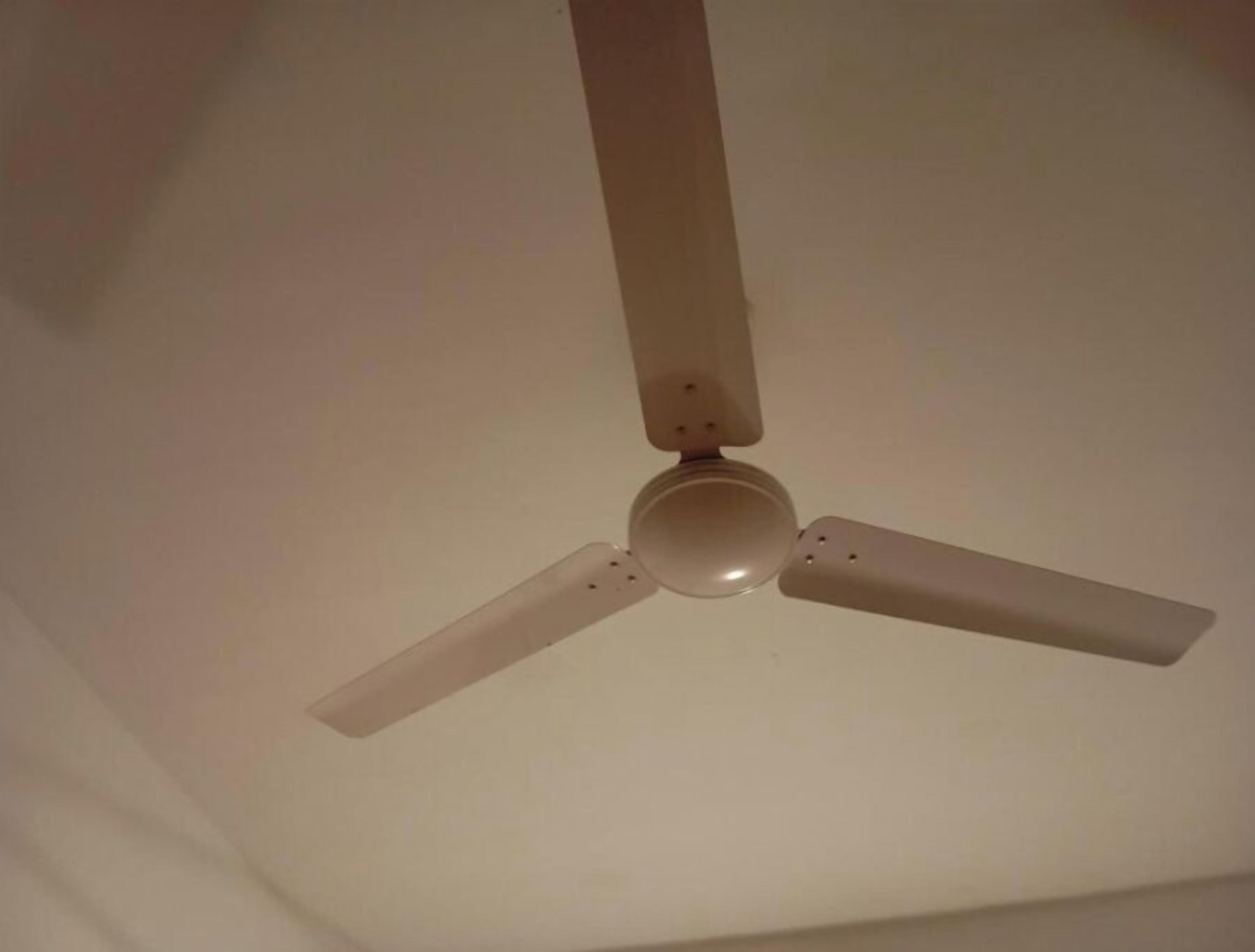 A ceiling fan with three blades and a central light fixture.