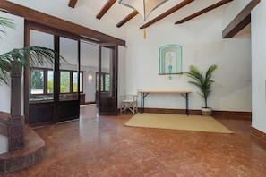 A spacious room with a wooden ceiling, a large window, a table, and a potted plant. - Luxurious finca with swimming pool near the beach. (El Puerto de Santa María)