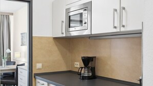 A kitchenette with a microwave, coffee maker, and a small refrigerator. - Cozy and quiet vacation apartment in the center of Bad Füssing (Bad Füssing)