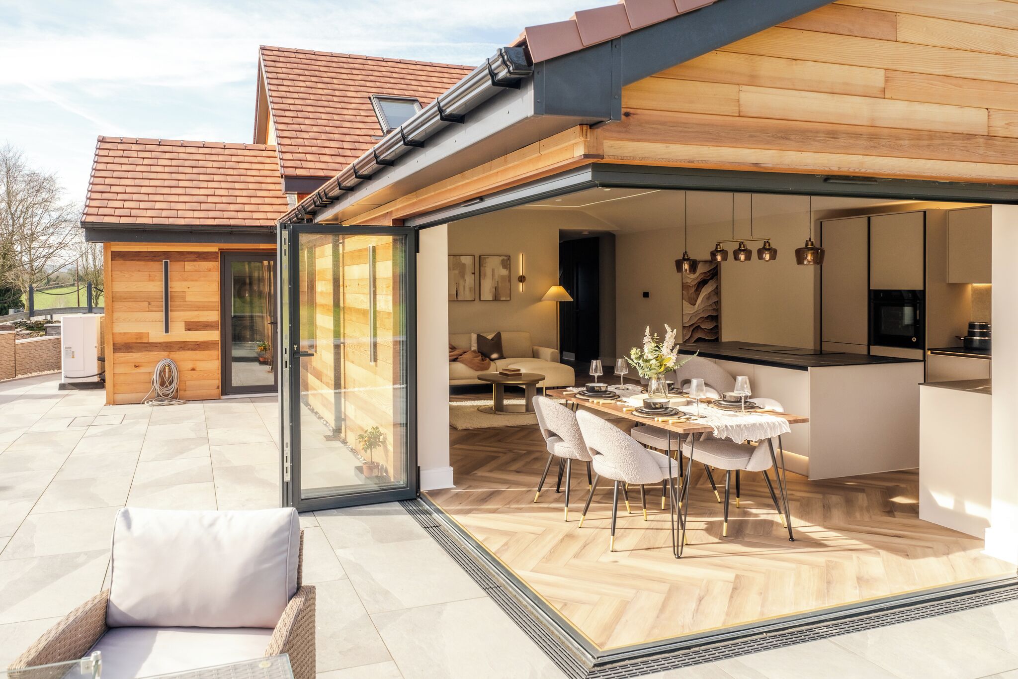 A modern house with a glass-enclosed dining area, a kitchen, and a living room.