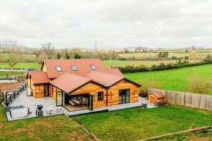 A wooden house with a sloped roof, a garage, and a fenced backyard. - Megan's Hideaway Luxury 4 Bed Retreat (Stourport-on-Severn)