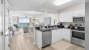 A modern kitchen with white cabinets, stainless steel appliances, and a large island. - 20% off 3-7 thru Dec. Oceanfront 2BR 2BA. Crescent Shores. Views!! Amenities!! (North Myrtle Beach)