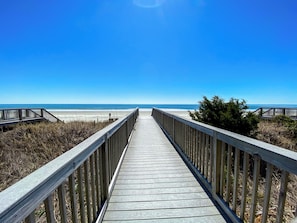 A wooden boardwalk leading to a beach with clear skies. - FAMILY FUN! Oceanfront 2 Bedrooms. Great amenities/location! (North Myrtle Beach)