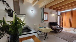 Une cuisine équipée d’une cuisinière, d’un évier et d’un coin repas avec une table et des chaises.