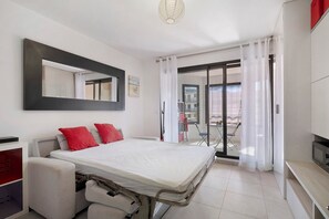 A modern bedroom with a bed, a desk, and a chair. - Rives Bleues Juan les Pins – Modern Studio with Loggia (Antibes)