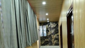 Un pasillo con paredes de madera, suelo de mármol e iluminación empotrada en el techo.