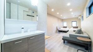 Una moderna camera d'albergo con uno specchio grande, un divano, un tavolino e un letto.