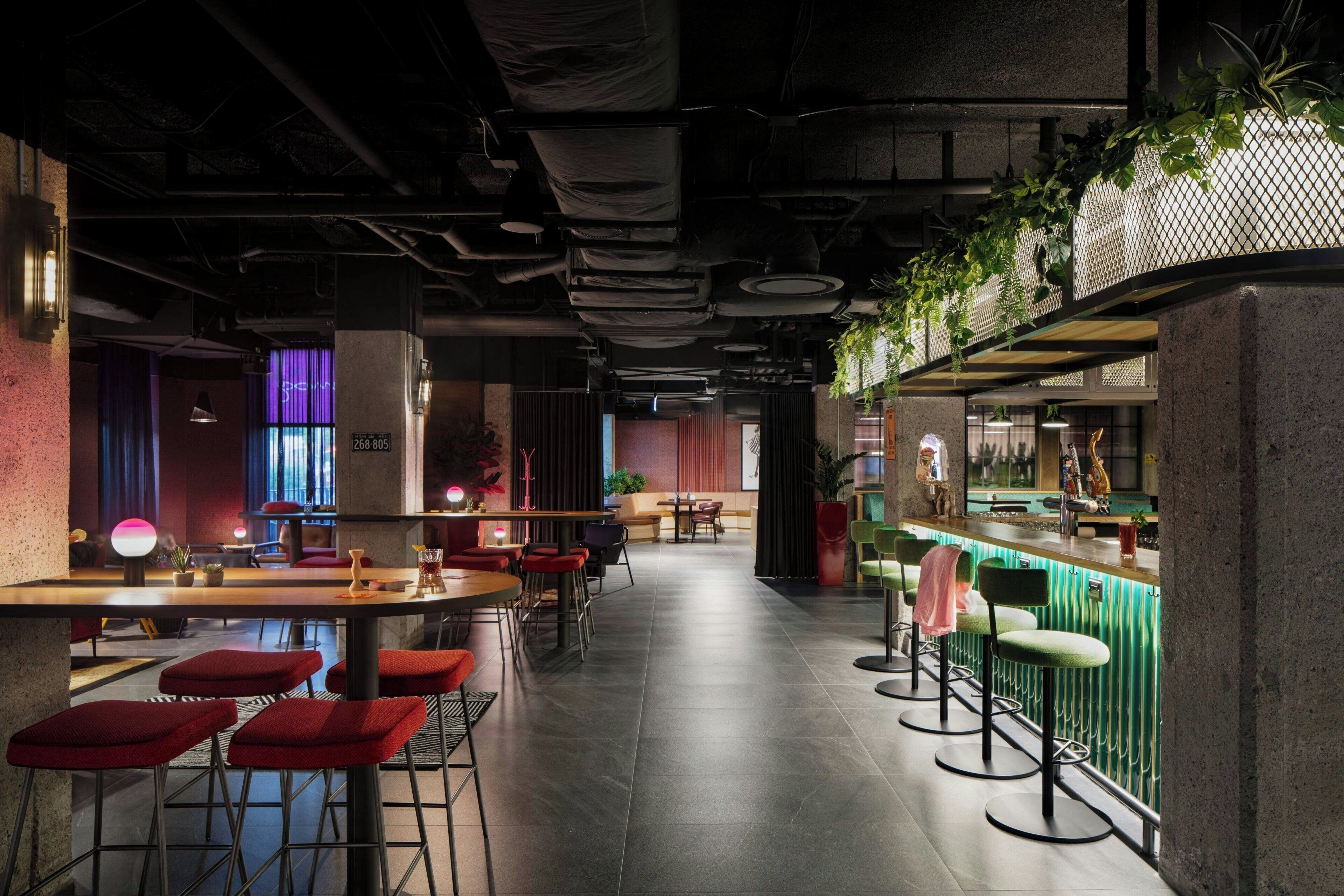 A modern bar area with high stools, a counter, and a mix of seating options.