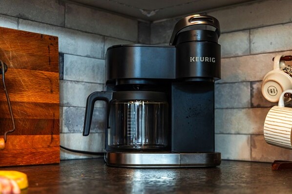 A black Keurig coffee maker with a clear carafe on a kitchen counter.