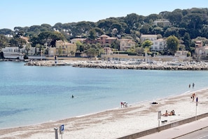 Un pueblo costero con playa, edificios y un litoral rocoso.