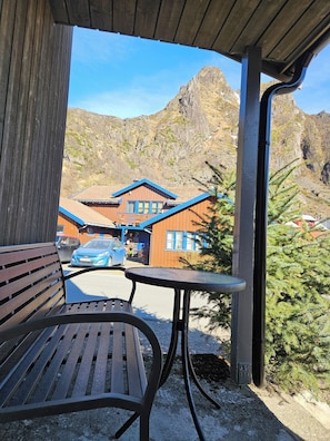 Eine Holzbänke und -tische befinden sich unter einem Schutzdach mit Blick auf die Berge.