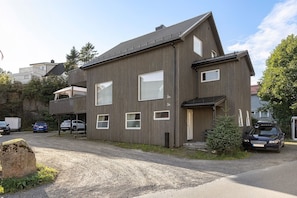 Ein zweistöckiges Gebäude mit Balkon, Garage und Auffahrt.